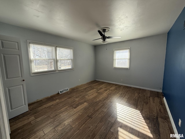 spare room with ceiling fan and dark hardwood / wood-style flooring