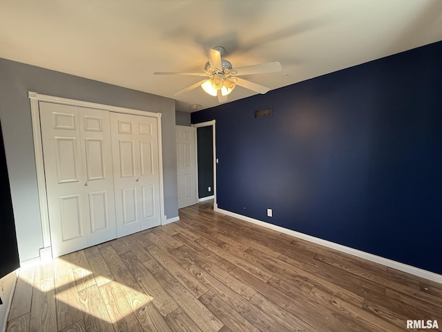 unfurnished bedroom featuring light wood-type flooring, ceiling fan, and a closet