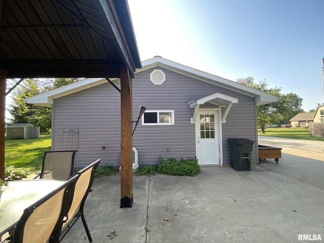 rear view of house with a patio area and a storage shed