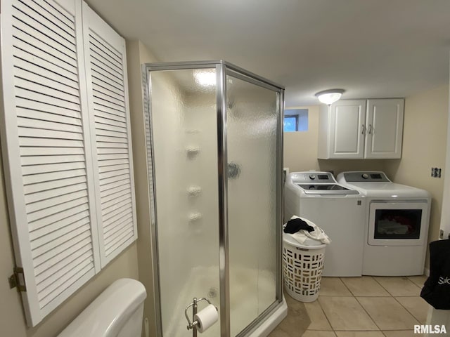 bathroom featuring a shower with shower door, tile patterned floors, and separate washer and dryer