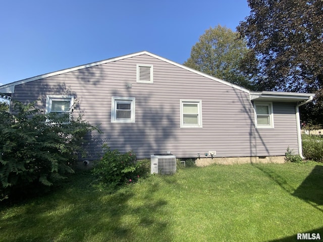 view of home's exterior with cooling unit and a yard