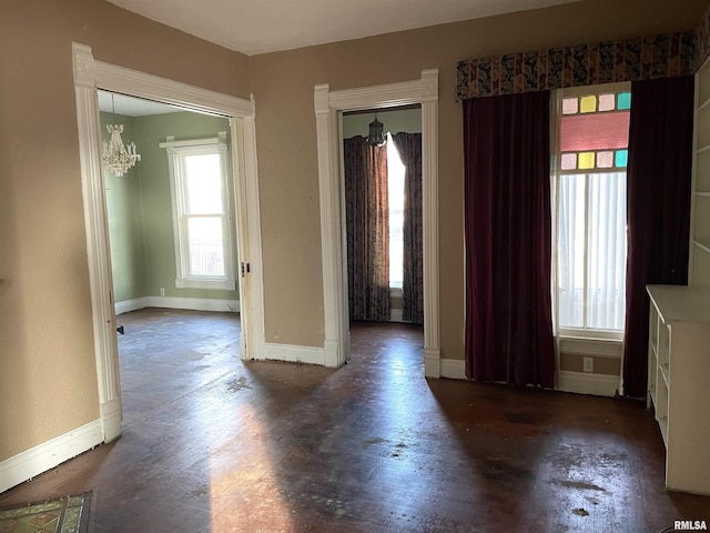 spare room with a healthy amount of sunlight and a chandelier