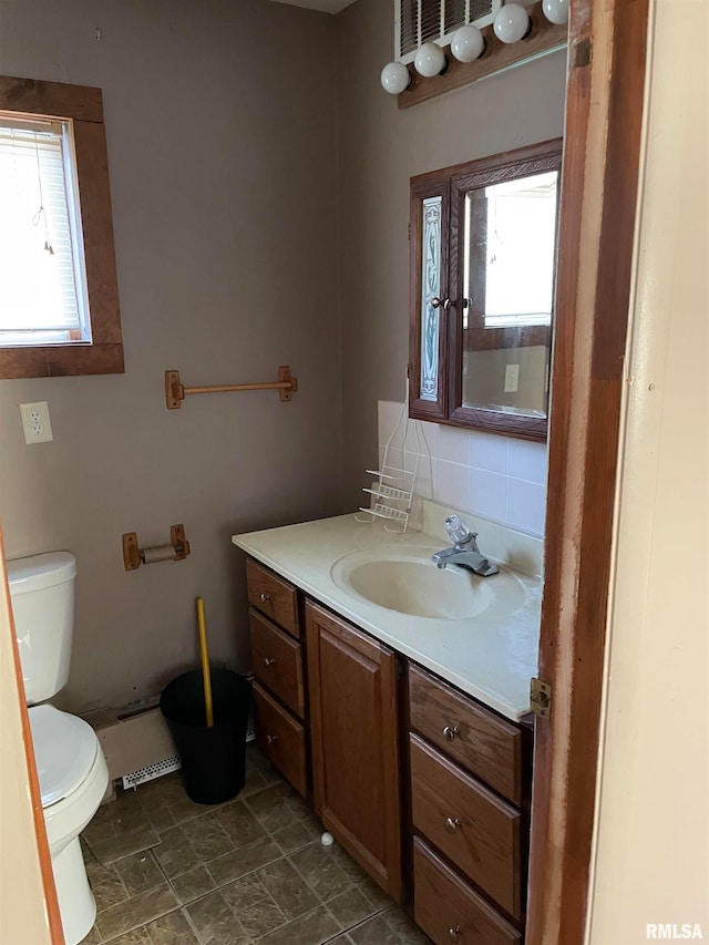 bathroom featuring vanity, plenty of natural light, tile floors, and toilet