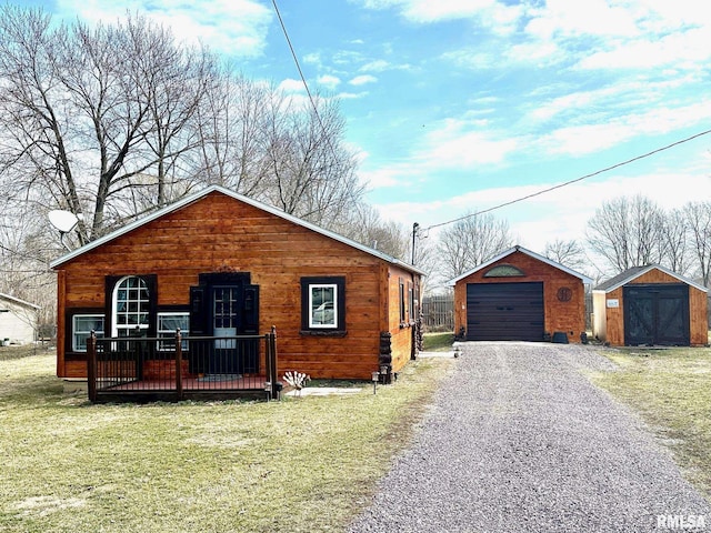 view of front facade with a front yard, a deck, a shed, and a garage