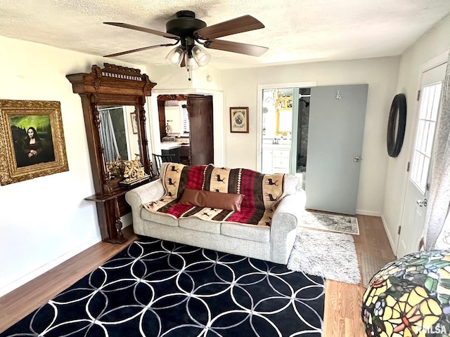 living room with wood-type flooring, a textured ceiling, and ceiling fan
