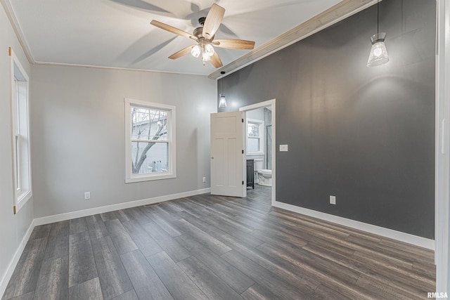 empty room featuring crown molding, lofted ceiling, dark wood-type flooring, and ceiling fan