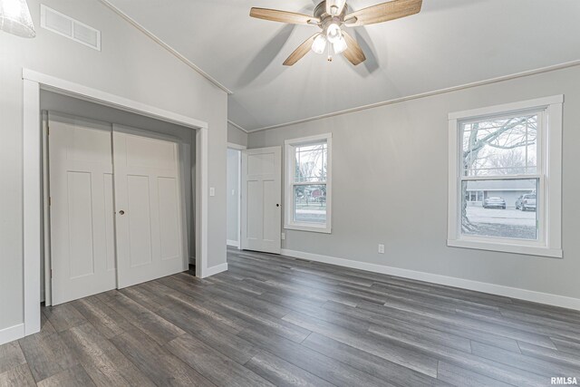 unfurnished bedroom with multiple windows, dark hardwood / wood-style flooring, lofted ceiling, and ceiling fan