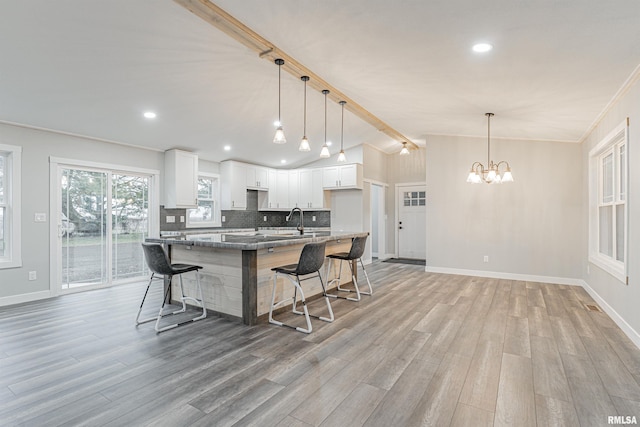 kitchen with hanging light fixtures, light hardwood / wood-style floors, and white cabinetry