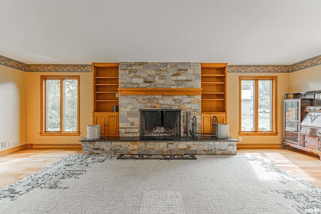 unfurnished living room with light hardwood / wood-style floors, plenty of natural light, and a fireplace