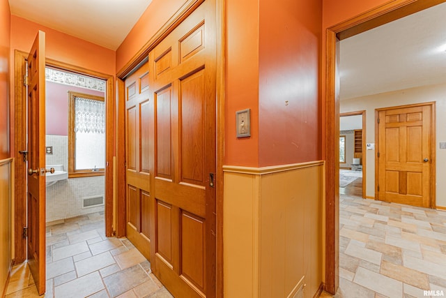 corridor featuring light tile patterned flooring and plenty of natural light