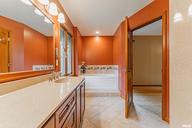 bathroom with a bath, vanity, and tile patterned flooring