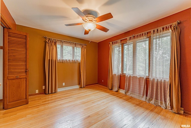 spare room featuring ceiling fan, light hardwood / wood-style flooring, and a baseboard heating unit