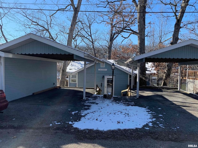 snow covered property with a carport