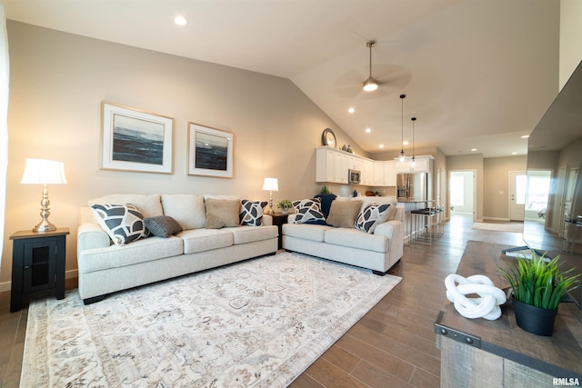 living room featuring hardwood / wood-style flooring, vaulted ceiling, and ceiling fan