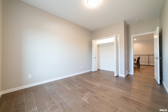 unfurnished bedroom featuring hardwood / wood-style floors and a closet