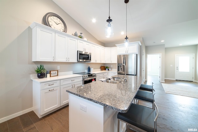 kitchen with stainless steel appliances, sink, a breakfast bar area, and white cabinets