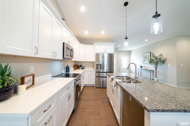 kitchen with hanging light fixtures, stainless steel appliances, sink, and white cabinets