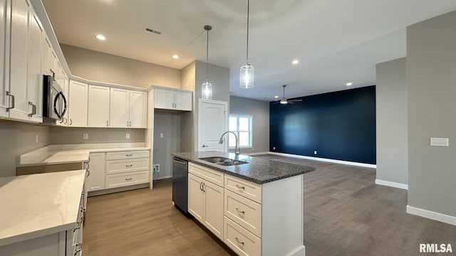 kitchen featuring visible vents, dishwasher, wood finished floors, black microwave, and a sink