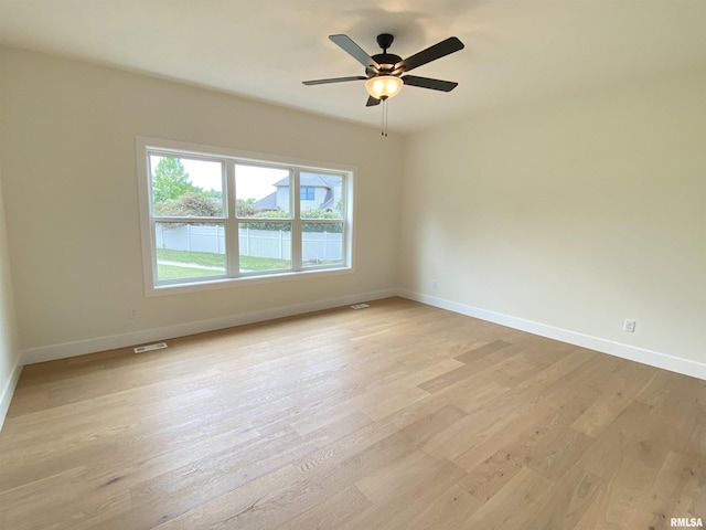 unfurnished room featuring light wood finished floors, baseboards, and a ceiling fan