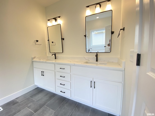 bathroom with wood tiled floor, a sink, baseboards, and double vanity