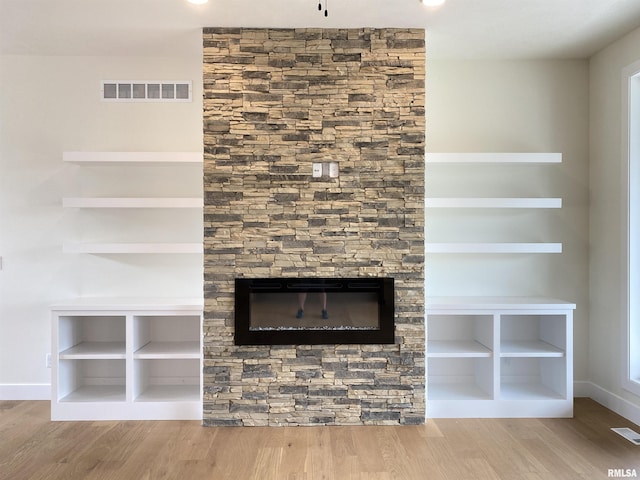 room details featuring visible vents, baseboards, and wood finished floors