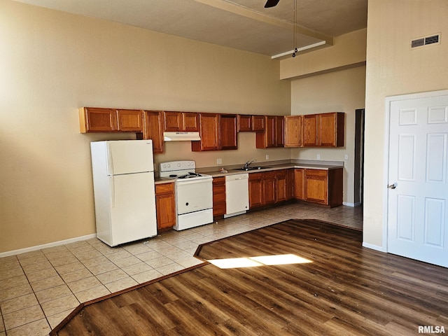 kitchen featuring sink, a towering ceiling, white appliances, ceiling fan, and light tile patterned floors