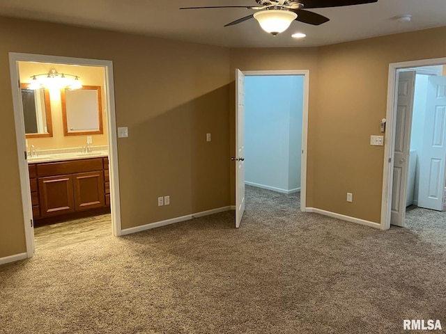 unfurnished bedroom featuring light carpet, ceiling fan, sink, and ensuite bath