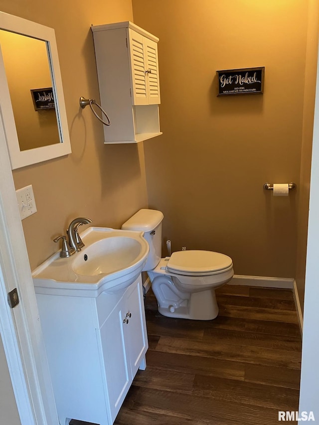 bathroom featuring hardwood / wood-style flooring, toilet, and vanity