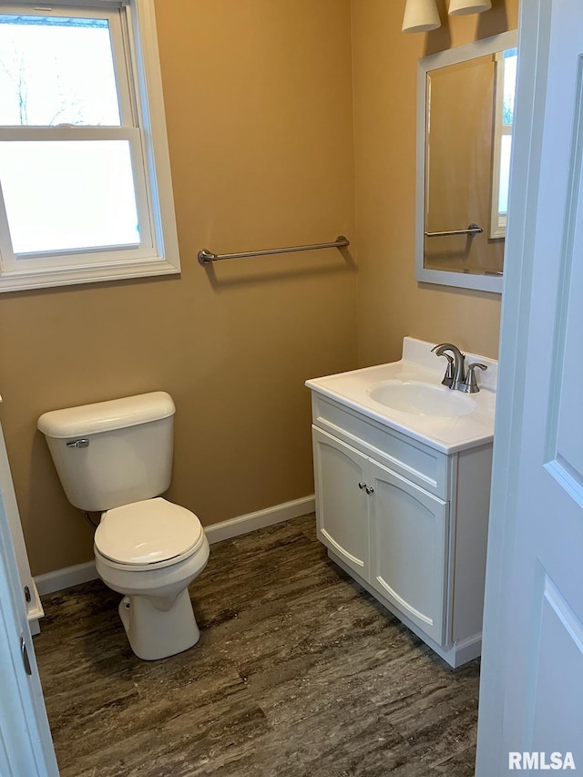 bathroom featuring toilet, vanity, and hardwood / wood-style floors