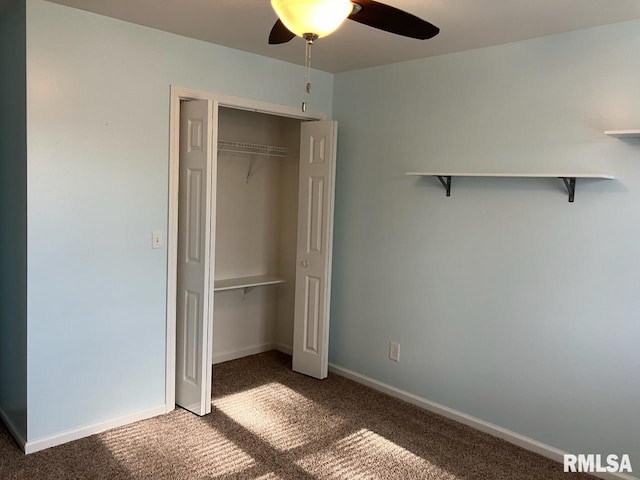 unfurnished bedroom with ceiling fan, a closet, and dark carpet