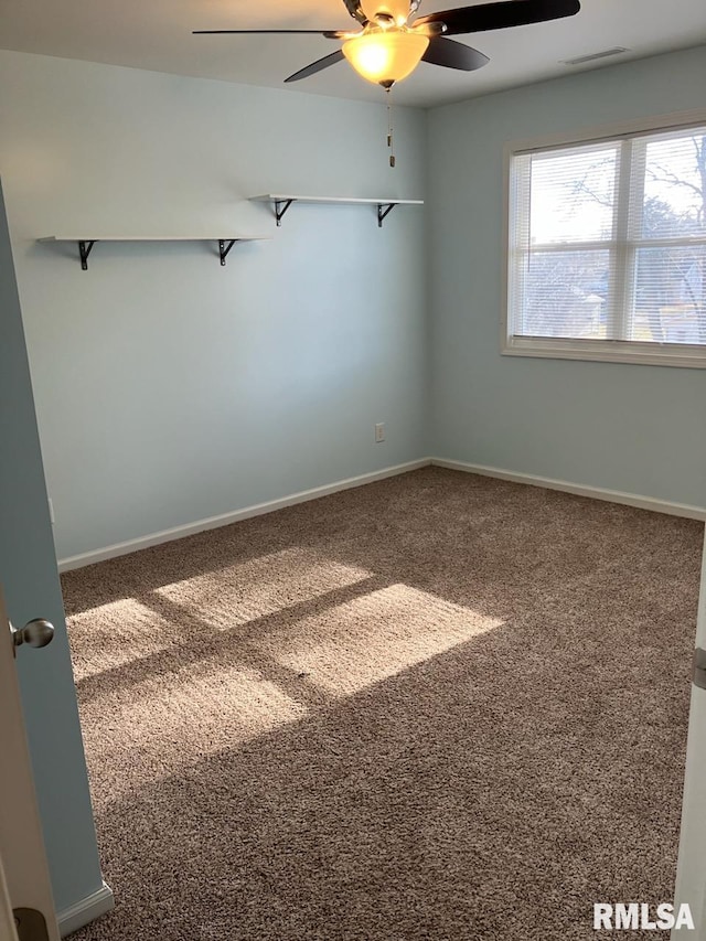 carpeted spare room with ceiling fan