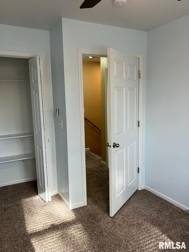 unfurnished bedroom with ceiling fan, a closet, and carpet flooring