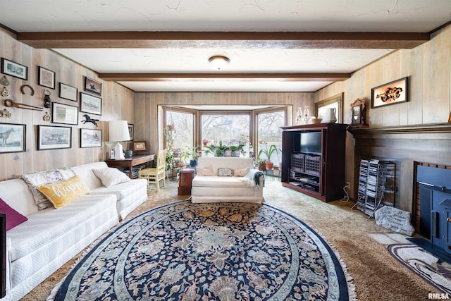 living room with wood walls, beamed ceiling, and carpet