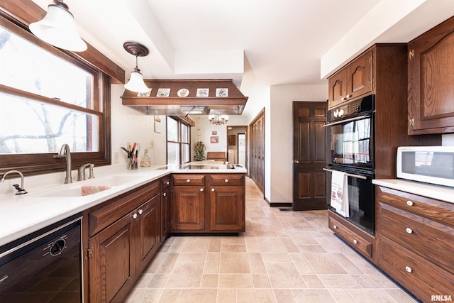 kitchen featuring light tile floors, plenty of natural light, black appliances, pendant lighting, and sink