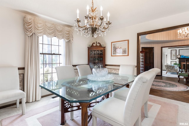 dining space featuring light parquet flooring and a chandelier