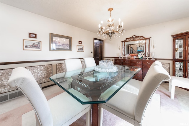 carpeted dining room featuring an inviting chandelier