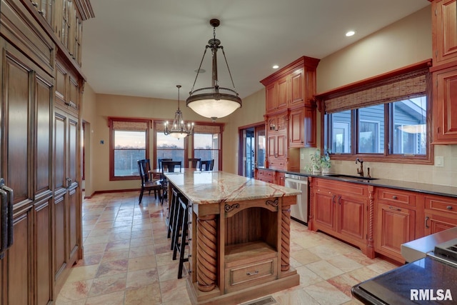 kitchen featuring sink, a kitchen island, decorative light fixtures, dishwasher, and decorative backsplash