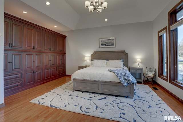 bedroom featuring an inviting chandelier and light hardwood / wood-style flooring