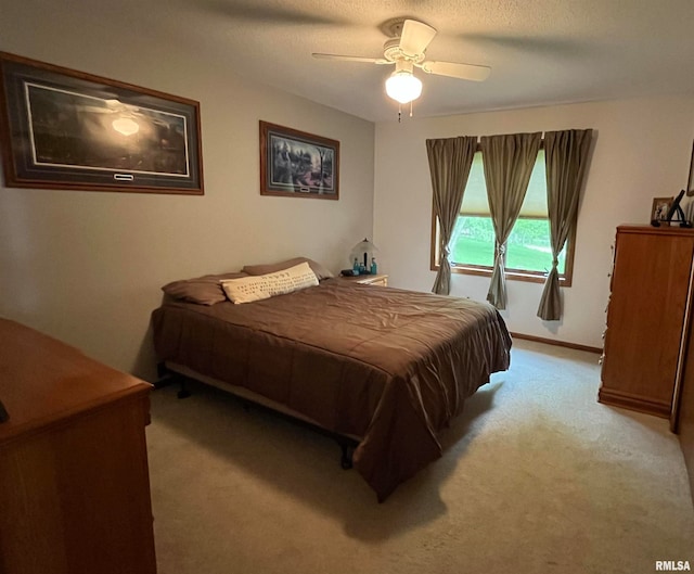 carpeted bedroom with ceiling fan and a textured ceiling