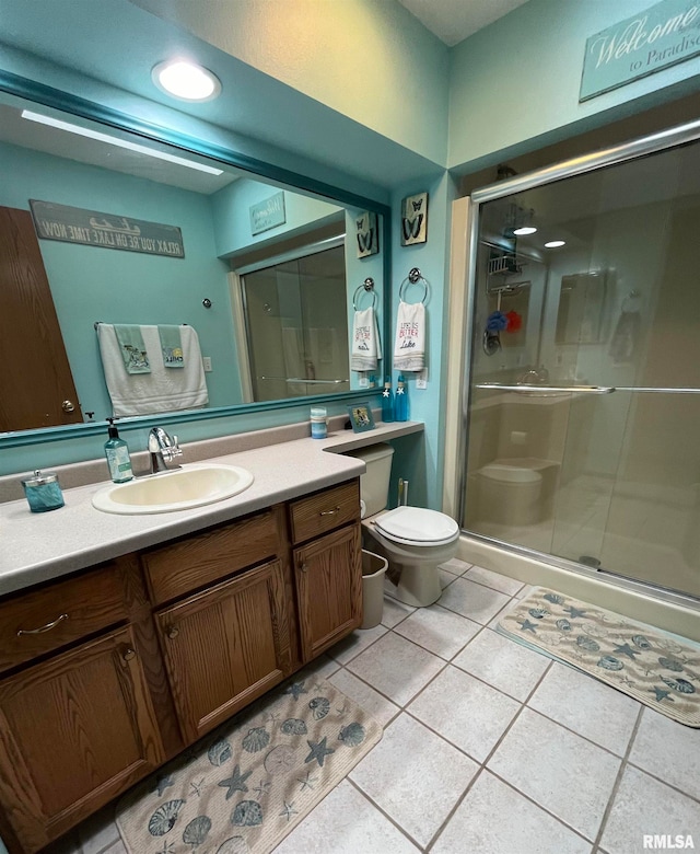 bathroom with vanity with extensive cabinet space, an enclosed shower, toilet, and tile flooring