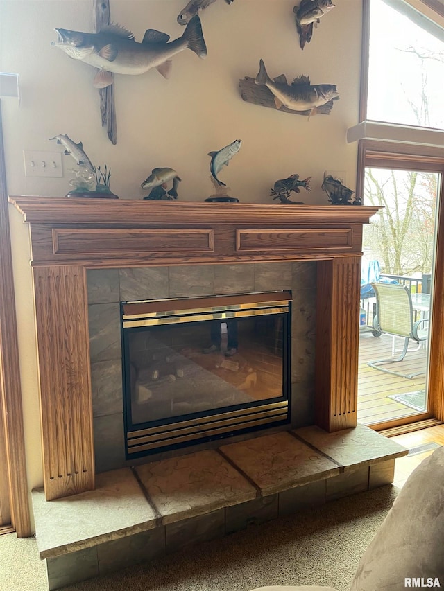 interior details with carpet flooring and a tiled fireplace