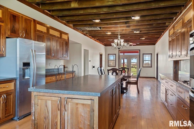 kitchen featuring a chandelier, a center island, decorative light fixtures, french doors, and stainless steel fridge with ice dispenser