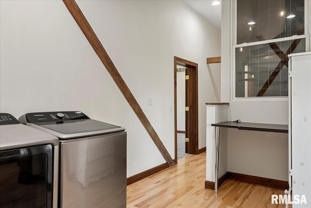 washroom with independent washer and dryer and light hardwood / wood-style flooring