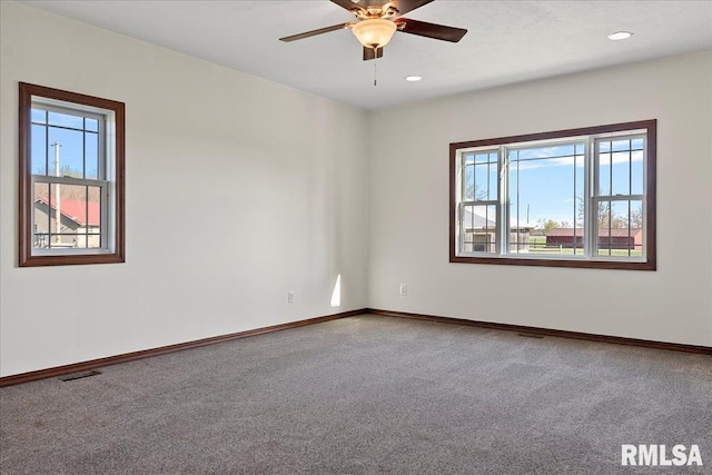 empty room featuring ceiling fan and carpet