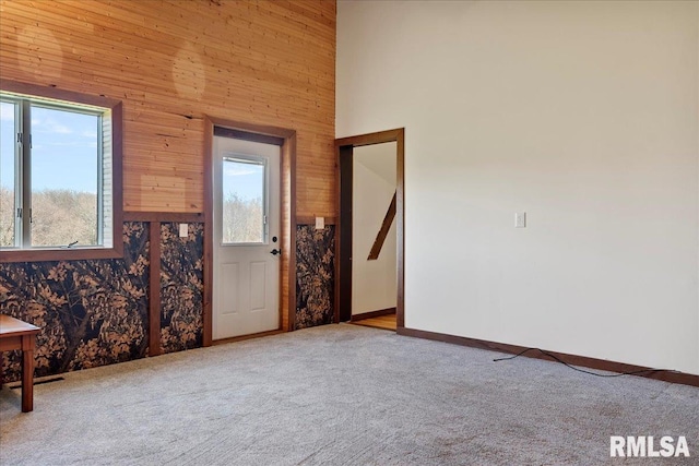 empty room with a high ceiling and light carpet