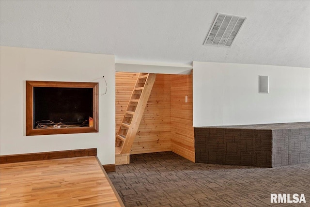 unfurnished living room with wood walls