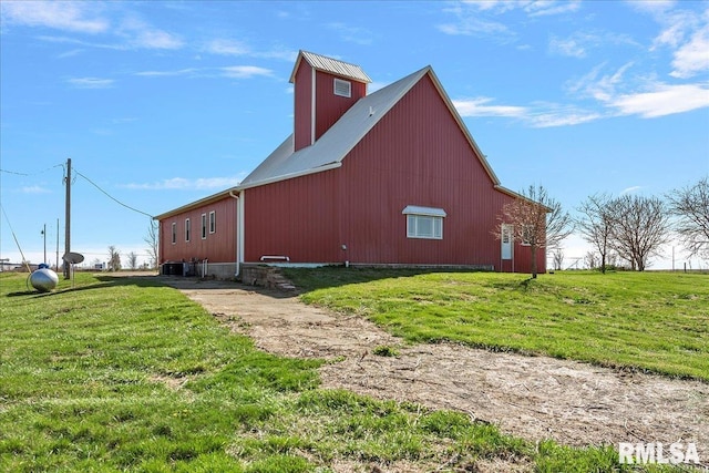 view of side of property featuring central air condition unit, a yard, and an outdoor structure