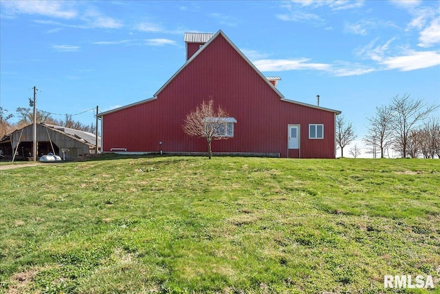 view of side of home featuring an outdoor structure and a lawn