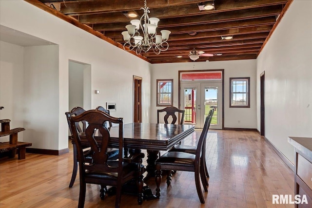 dining space with ceiling fan with notable chandelier, french doors, hardwood / wood-style floors, and beamed ceiling