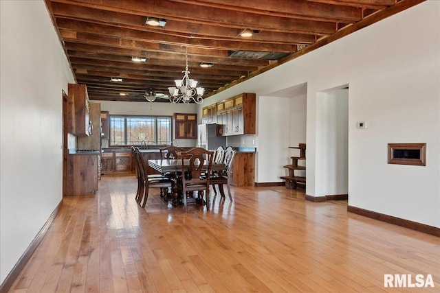 dining room with a notable chandelier, light hardwood / wood-style flooring, and beam ceiling